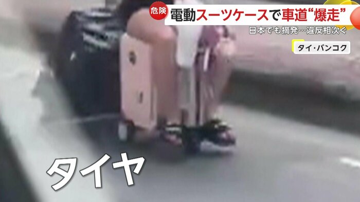 電動で走るスーツケースに乗り、女は公道を走行していた
