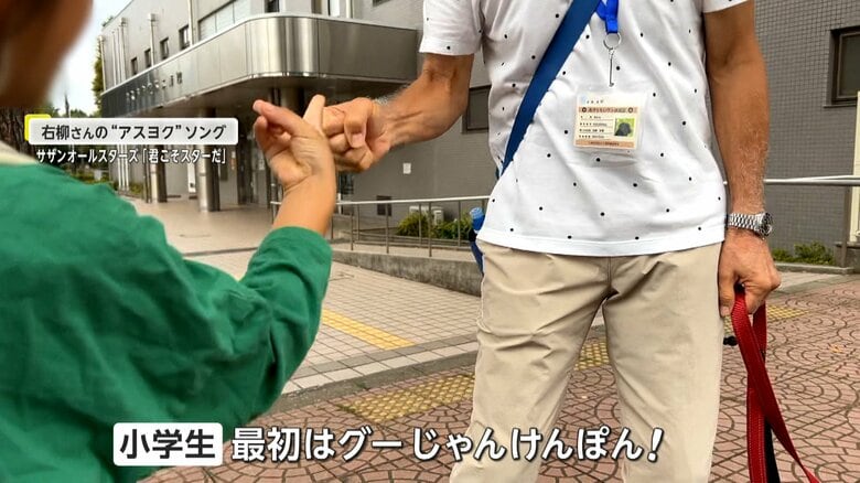 朝の通学路で小学生とじゃんけんをする、右柳さん