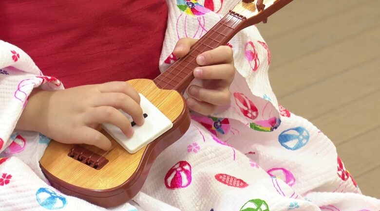 華穂ちゃんはおもちゃのギターでお姉ちゃんの真似をする