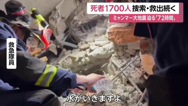 男性に水を与える救急隊員