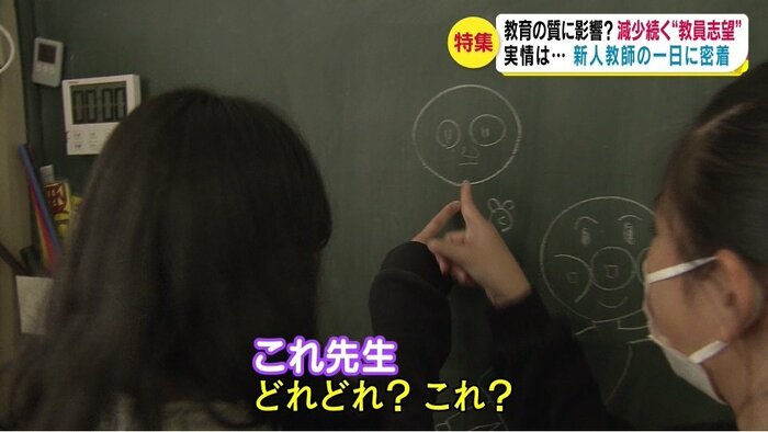 昼休み、児童が黒板に先生の似顔絵を描く