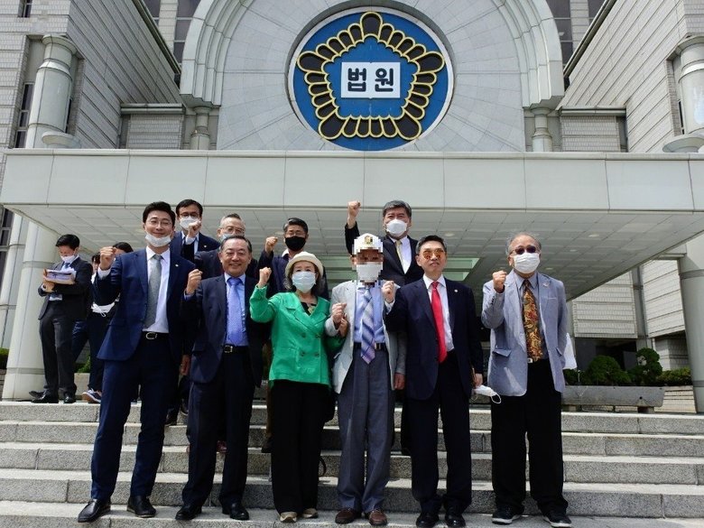 金委員長に賠償支払いを命じる判決を受けて喜ぶ元捕虜の原告ら ※一部画像を加工しています