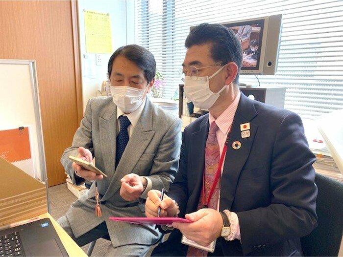 音声文字変換アプリなどを使い、ほかの秘書とコミュニケーションをとる川﨑さん(右)