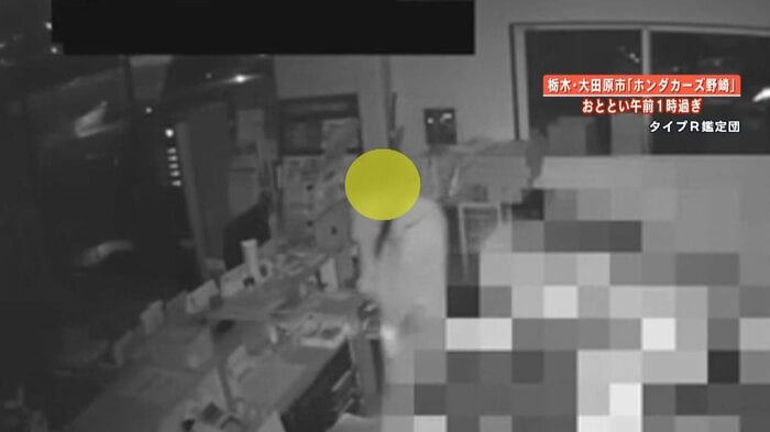 懐中電灯を手に事務所に侵入する不審者
