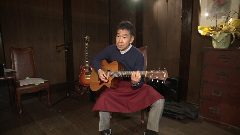 愛用のギターで弾き語りを楽しむ岸さん