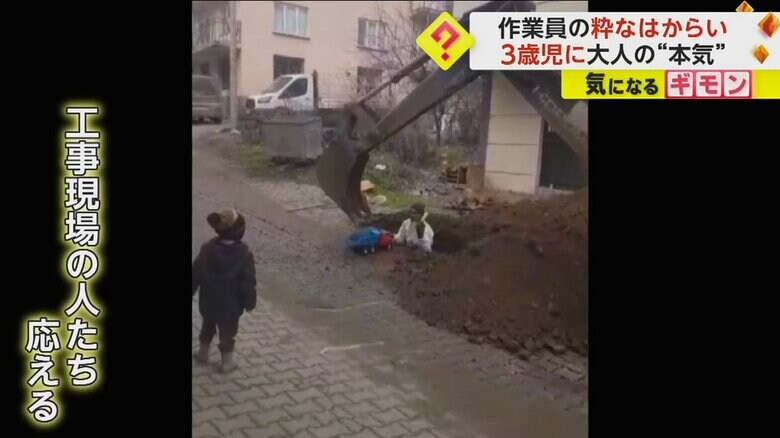 ショベルカーでおもちゃのトラックに砂を積む様子