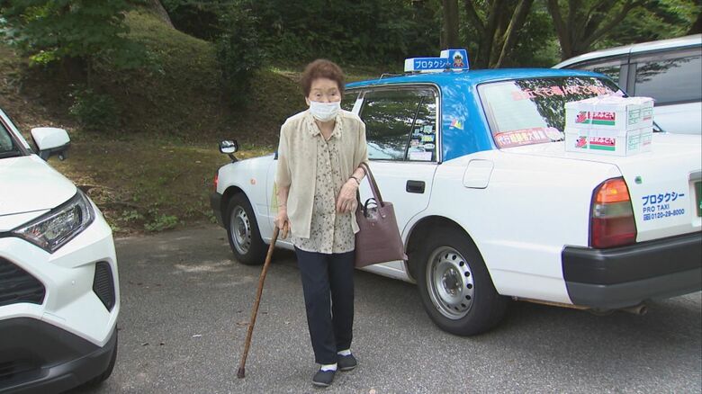 杖をついて歩く西村さん