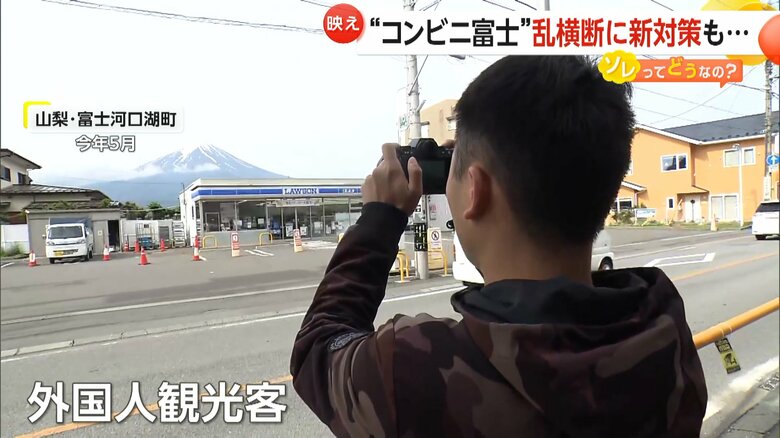 富士山とコンビニを一緒に撮ろうとする外国人観光客