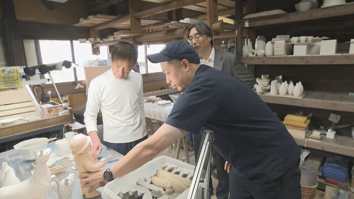 完成した人形を柿右衛門さんに見せる中村さん