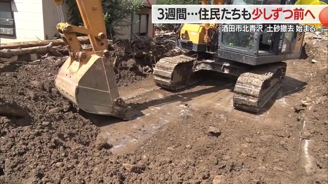 道路に1メートルほどたまった土砂を重機で撤去している様子