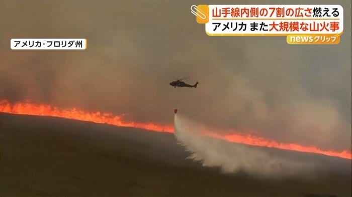 上空から放水するヘリ