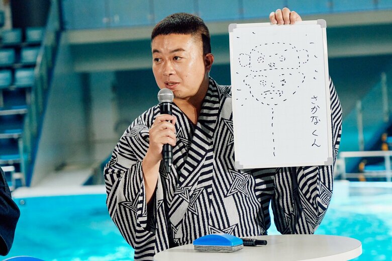さかなクンの似顔絵を手に持つ松尾駿さん