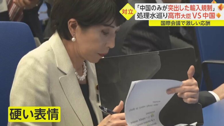 黒いバインダーを広げ、資料を確認する高市大臣