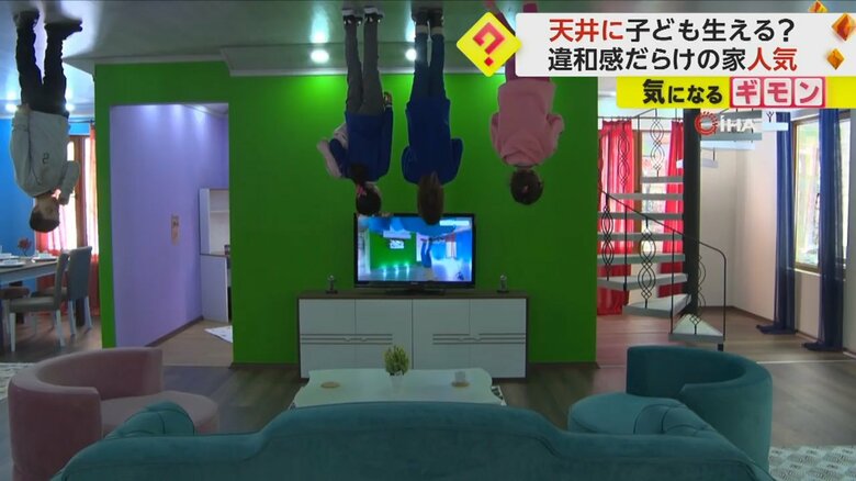 ソファが置かれたリビングで、子供たちが逆さまの状態でテレビを見ている