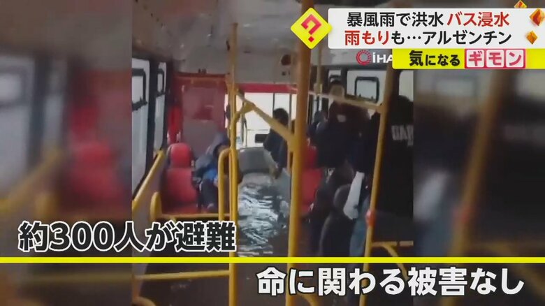 泥水を避けようと、バスの中で立ち上がる乗客たち