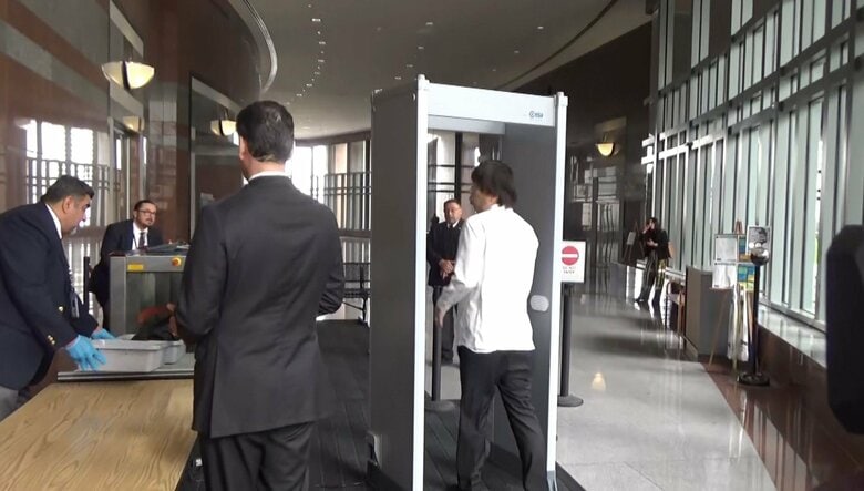 裁判所の金属探知機を通る水原被告