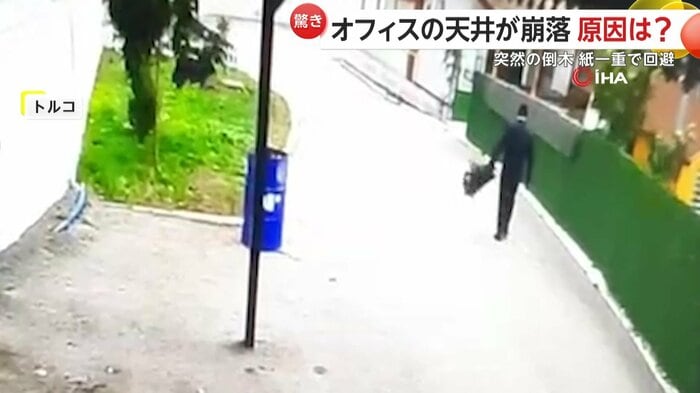 強風の中で道を歩いていた男性