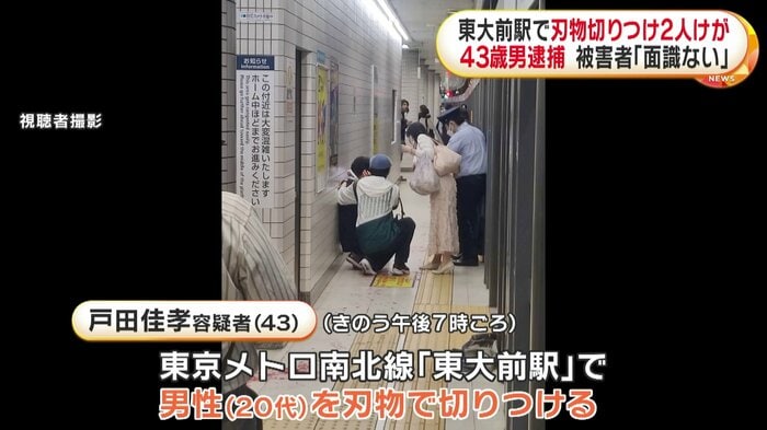 ホームで座り混む人、その下には血が点々と続いている