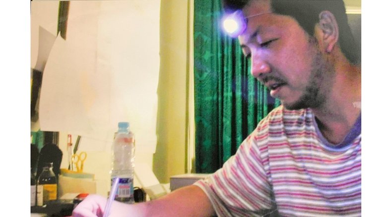 取材陣が滞在したホテルの壁には旧ソ連に攻め込まれた時の銃弾の跡が生々しく残っていた 度々停電するためヘッドライトを付けて仕事をする筆者