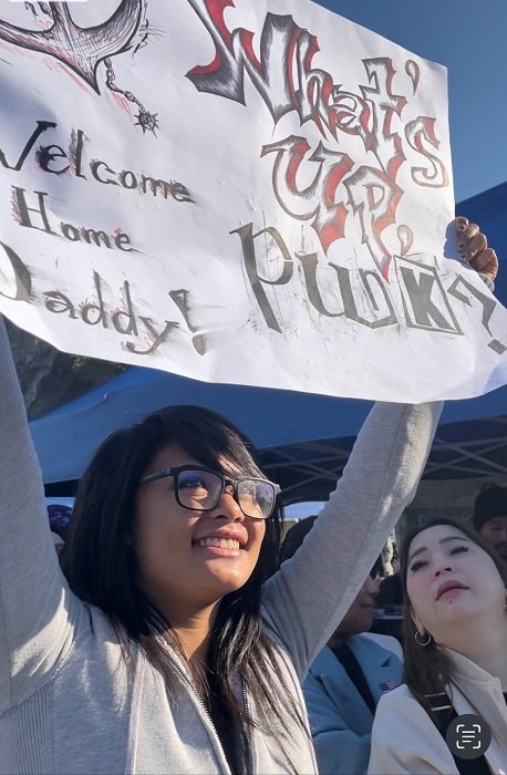 父親を待つ高校生。船の姿が見える前からずっとプラカードを持ち上げていた