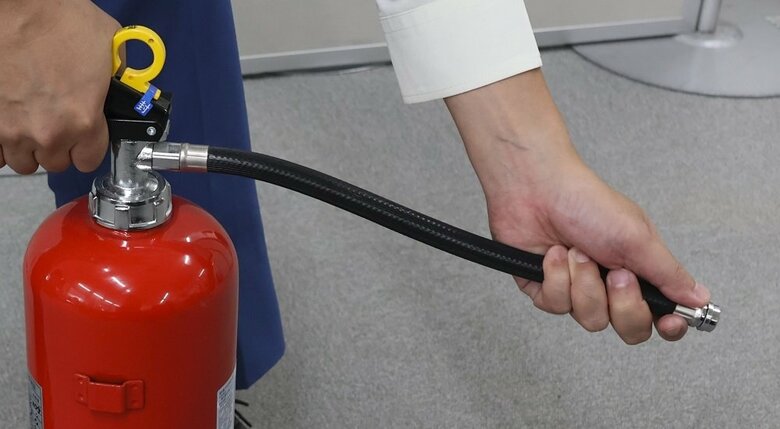 ホースの先をしっかりと持つ（編集部撮影）