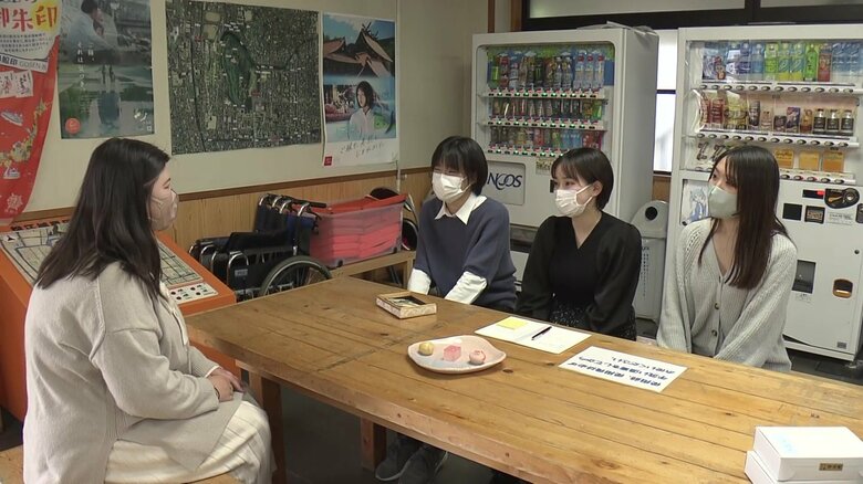 受付で出迎える3人の女子学生