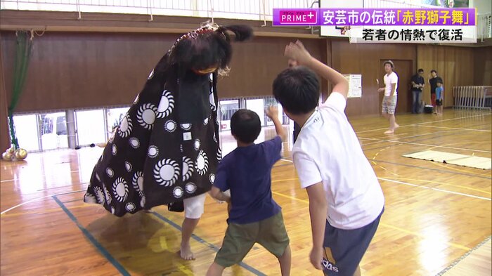 獅子(左奥)と獅子をからかう「テガイコ」の役の子どもたち