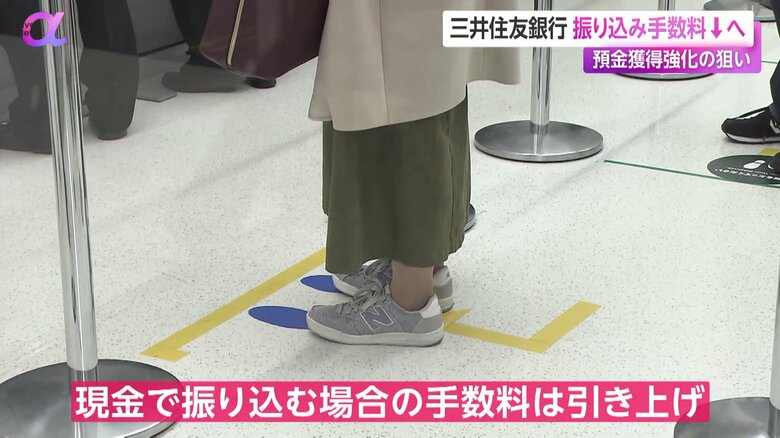 銀行のATM利用のため、順番を待つ人の足元