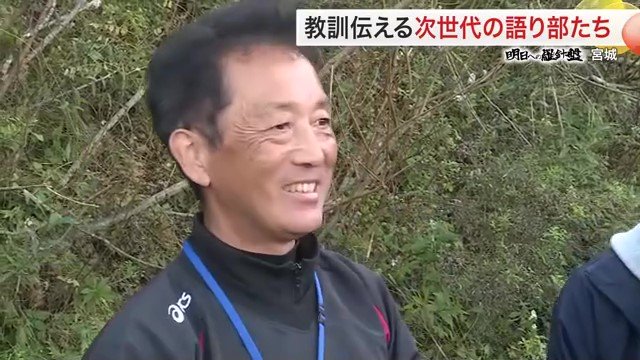 語り部を見守る鈴木典行さん