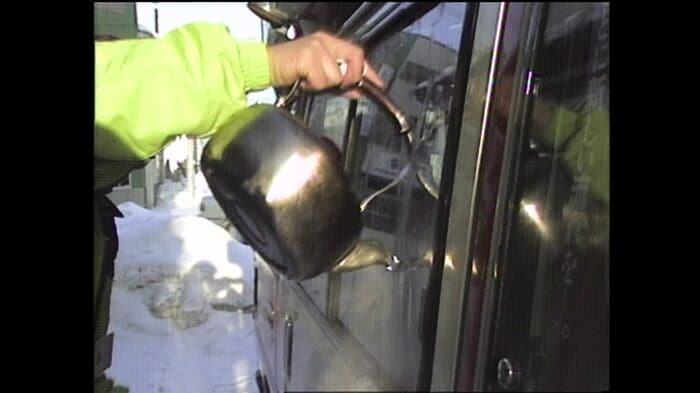 凍った窓をお湯でとかす選挙運動員