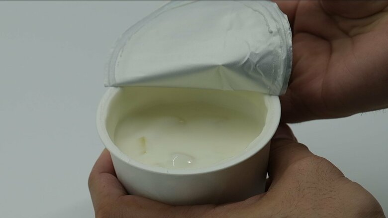 傾けたカップタイプのヨーグルト。開封してもフタの裏にはきれいなまま（提供：東洋アルミニウム）