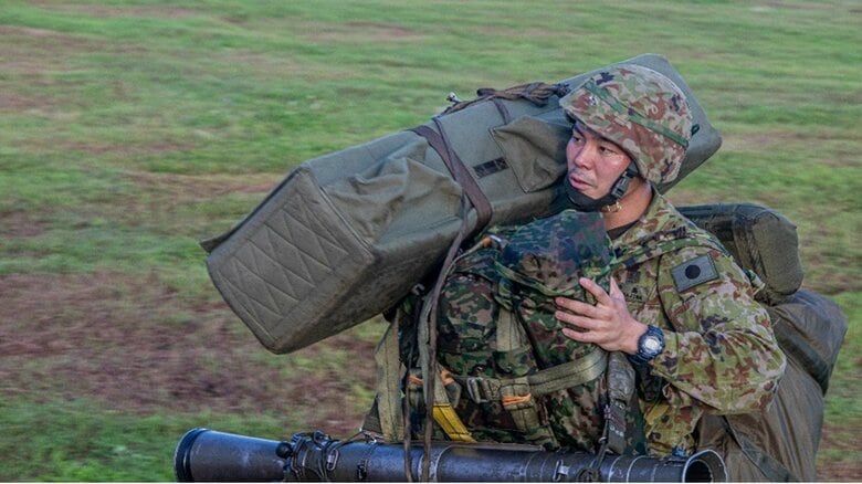 主傘(約17kg)や予備傘(約7kg)、荷物や装備品を入れる背のう(10～45kg)、鉄帽、小銃などを抱え降下する　提供：陸上自衛隊