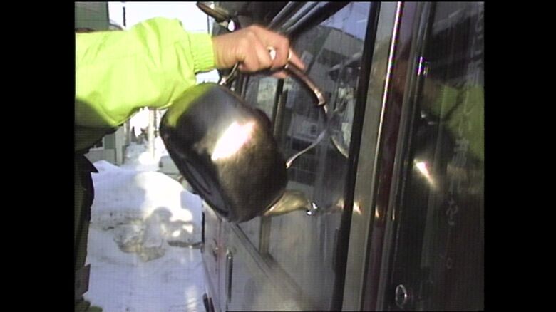 凍った窓をお湯でとかす選挙運動員