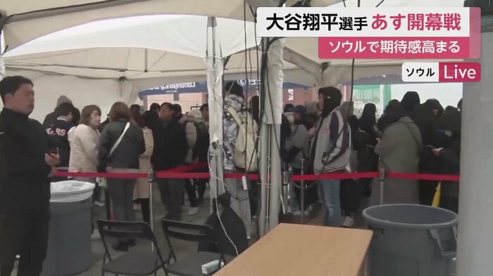雨が降る中球場前に設置されたテント下に並ぶ客