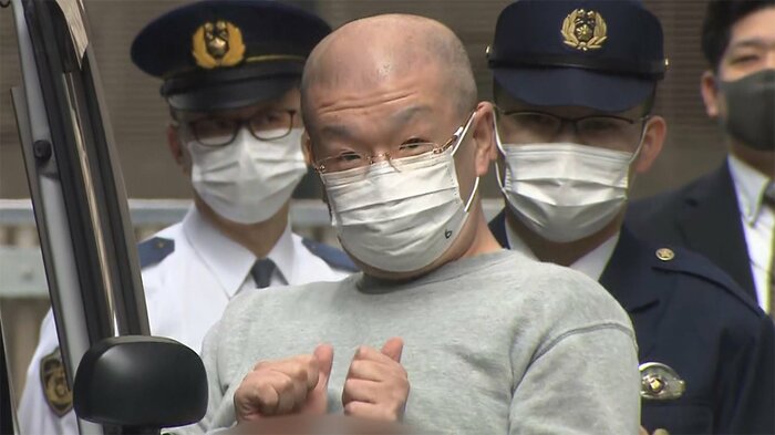 送検される大島智幸容疑者(48)。報道カメラに、「俺を撮っているのか?」とのジェスチャーを見せた。