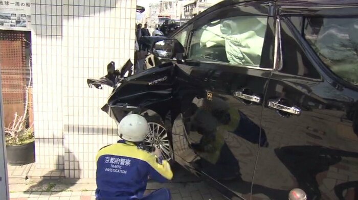 ビルの壁に衝突した黒色のタクシー