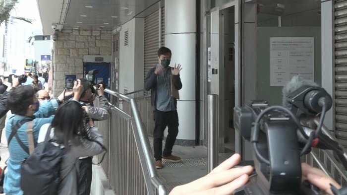 警察署に入る区さん 最後に「5大要求」実現を求めるハンドサインを見せた