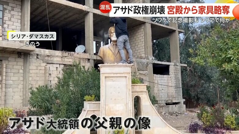 アサド大統領の父親の像を靴でたたく人