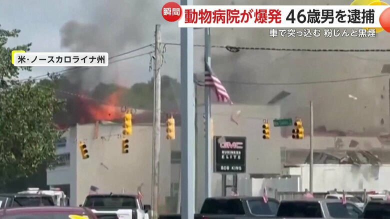 無数の破片と粉塵が舞い上がり、真っ赤な炎と黒煙が立ち上っている建物