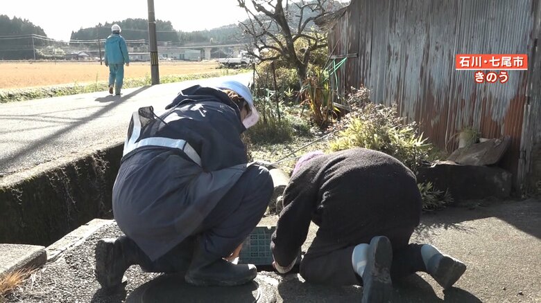 水道管を住人とチェックする職員