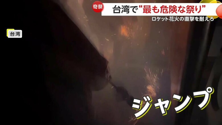 花火を浴びながらジャンプする人