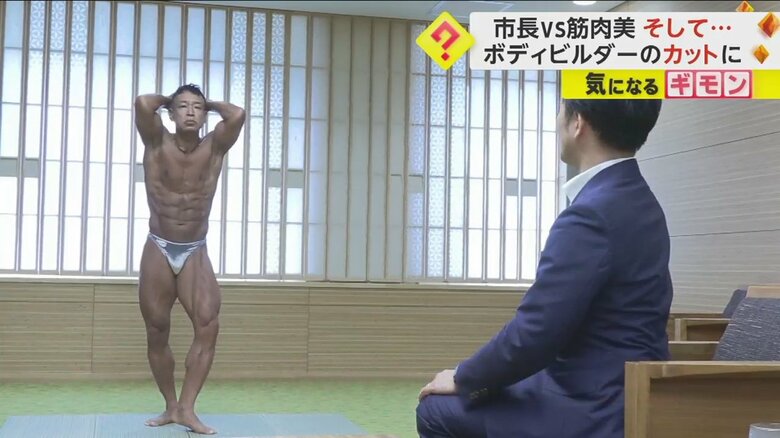 佐賀市の坂井英隆市長の前でポージングを決める、北原誠さん（54）
