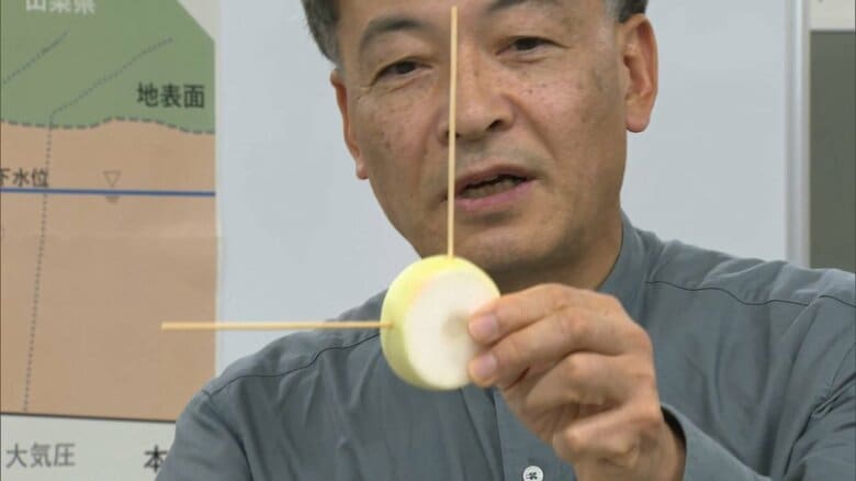 大根をトンネルにみたて説明する難波市長（2023年6月）
