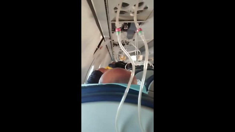 上から降りてきた酸素マスク　乗客が着用しているのが分かる