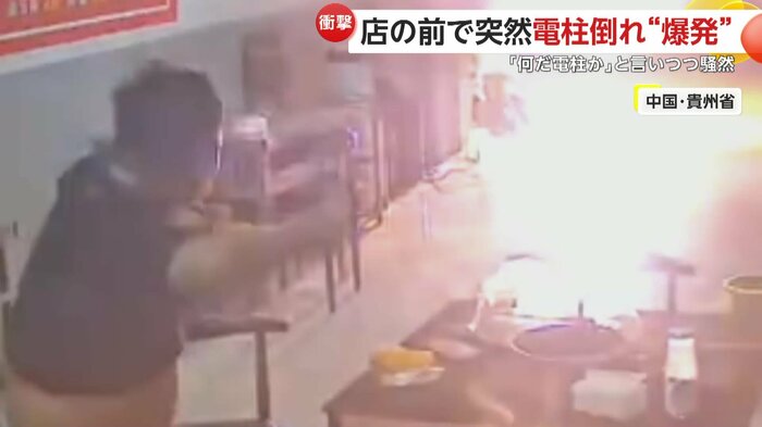 電柱から上がる炎に驚き、見つめる男性(中国SNSより)
