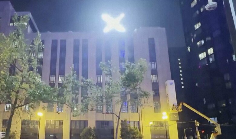 本社ビルに設置された「X」の看板