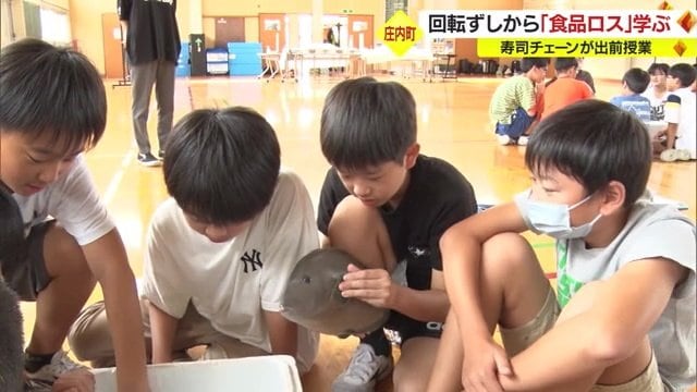 魚の模型を手に取る児童たち