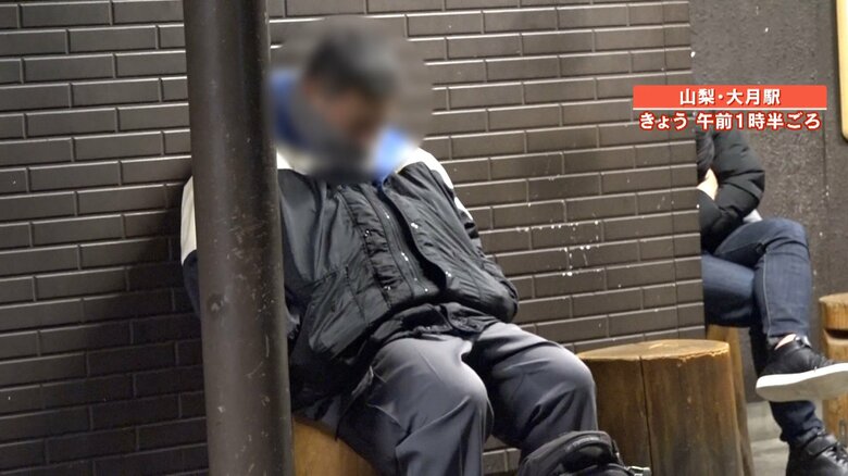 駅前の椅子に座り眠り始める男性
