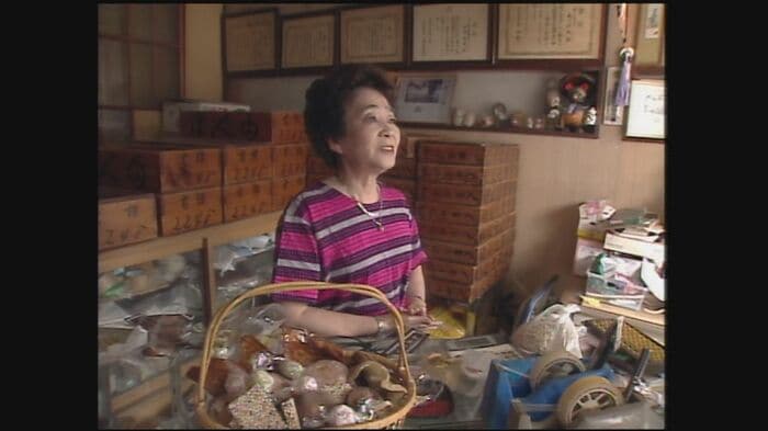 『ほんま屋』の店頭に立つ本間さん(2005年)