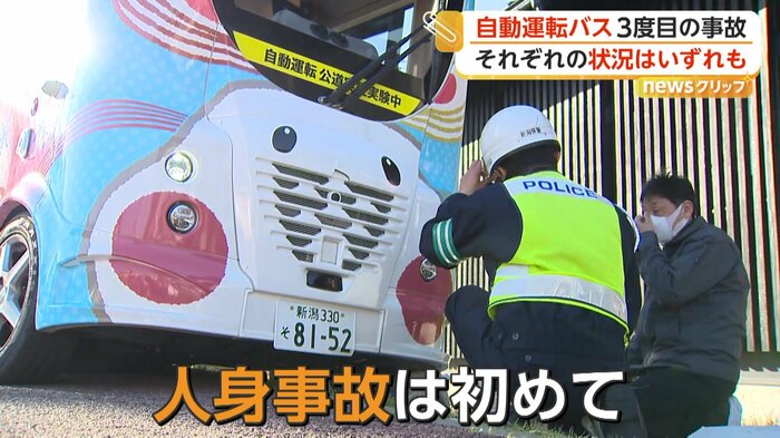 事故を起こしたバスと現場検証を行う警察官